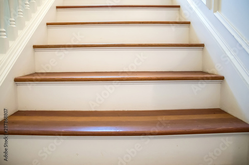 painted and natural stained wood stairs. Classic and tradition design with ornate banister