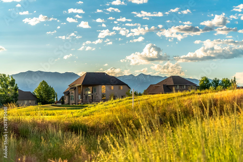 Lovely family homes on a grassy hill with distant mountain in the background