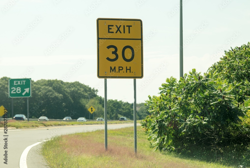 A road sign 30 MPH on EXIT, advise travelers to slow down on exit 