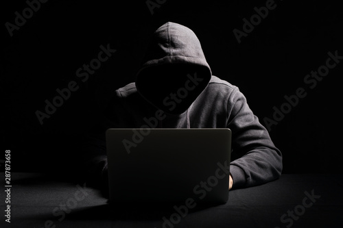 Leinwand Poster Hacker working on laptop in the dark