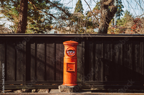 Foto Red vintgae Japanese mail letter postbox and black wooden wall