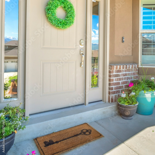 Square frame Front door with wreath transom window and sideligts at the facade of a home