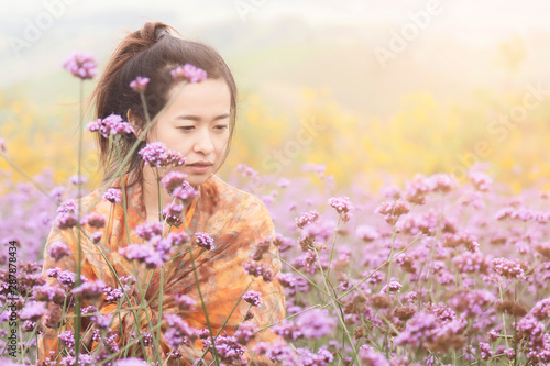 Romantic Asian women are standing to admire the beauty of flowers in the mountain gardens at Phetchabun province , Thailand.Travel with family cancept. photo