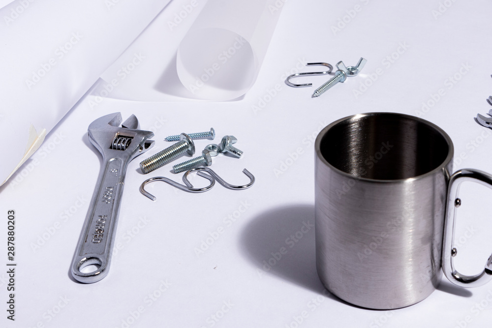 Escritorio de ingeniero con papel en blanco, llaves de expansión, tuercas, tornillos, herramientas para construir algo. Espacio de trabajo de un plomero o un constructor industrial. Escritorio de ingeniero con papel en blanco, llaves de expansión, tuercas, tornillos, herramientas para construir algo. Espacio de trabajo de un plomero o un constructor industrial.