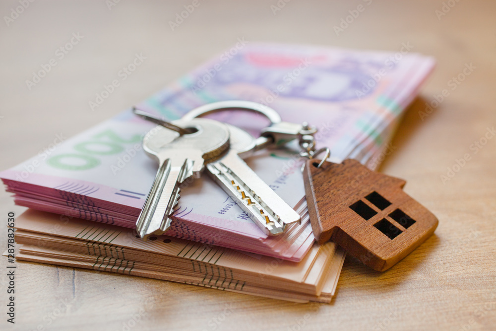 Real estate investing concept. Ukrainian hryvnia, cash or housing. Keys close up Real estate investing concept. Ukrainian hryvnia, cash or housing. Keys close up