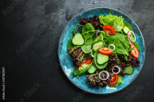 Healthy salad, leaves mix salad (mix micro greens, cucumber, tomato, onion, other ingredients). food background. copy space