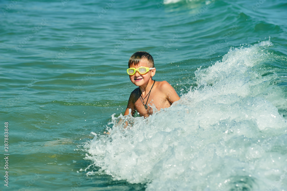 A little boy swimming in the sea . Happy child at the seaside resort
