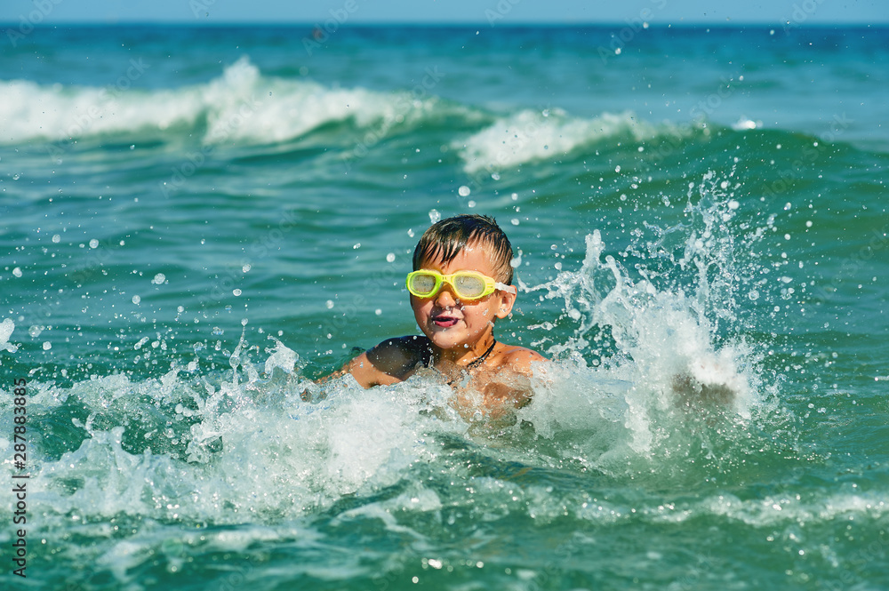 A little boy swimming in the sea . Happy child at the seaside resort