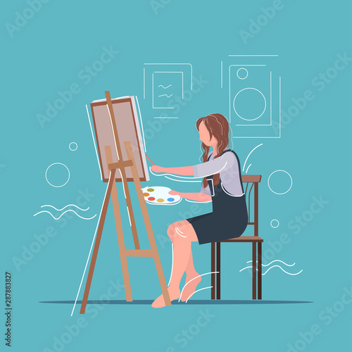 female painter using paintbrush and palette woman artist sitting in front of easel art creativity hobby creative occupation concept full length