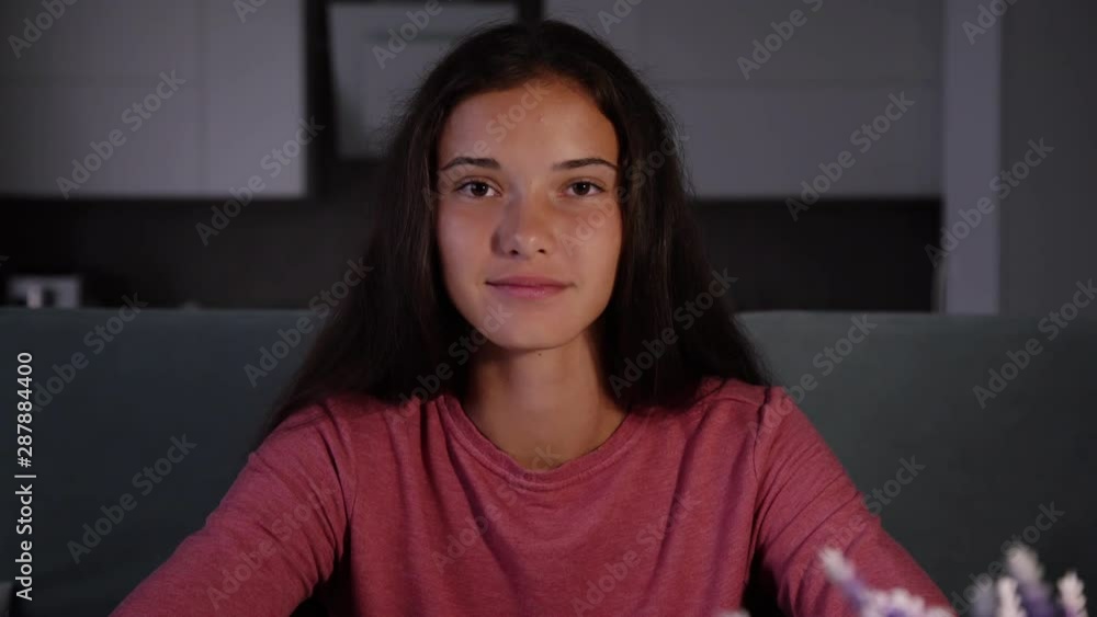 smiling dark haired girl in purple sweatshirt tells interesting things and shows different gestures in videochat closeup smiling dark haired girl in purple sweatshirt tells interesting things and shows different gestures in videochat closeup