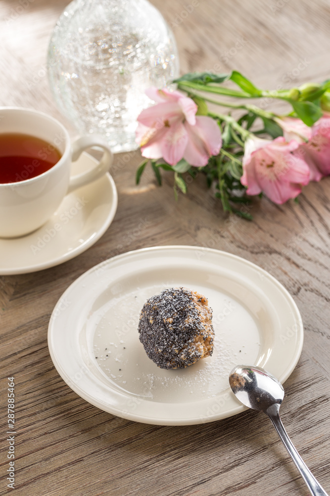 Homemade vegan Raw Energy Balls with honey, poppy seeds and coconut and cup of tea on wooden table Homemade vegan Raw Energy Balls with honey, poppy seeds and coconut and cup of tea on wooden table