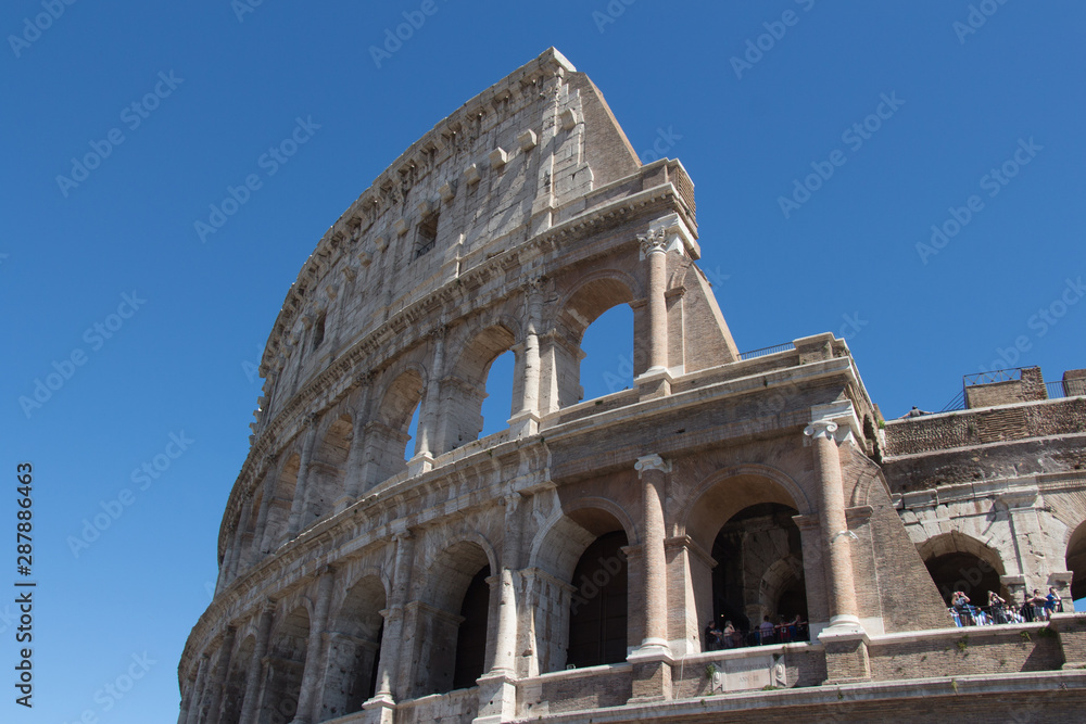 Detailed view of Colosseum with blue sky on background, Rome, Lazio, Italy.