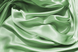 Delicate satin draped fabric green color texture backgrounds for holiday