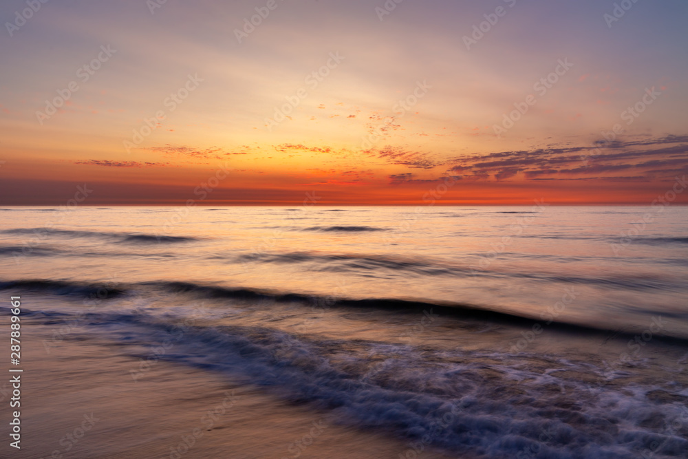 Colourful sky over the north sea after sunset at the beach on Juist, East Frisian Islands, Germany.