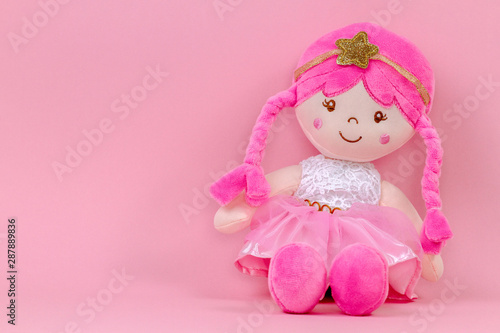 Stuffed soft doll sitting on pink background Fototapet