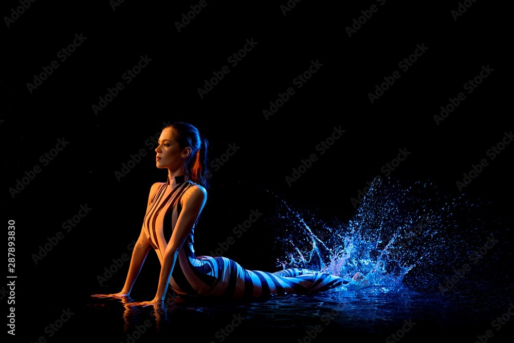 Fitness model view in water drops in the dark Fitness model view in water drops in the dark