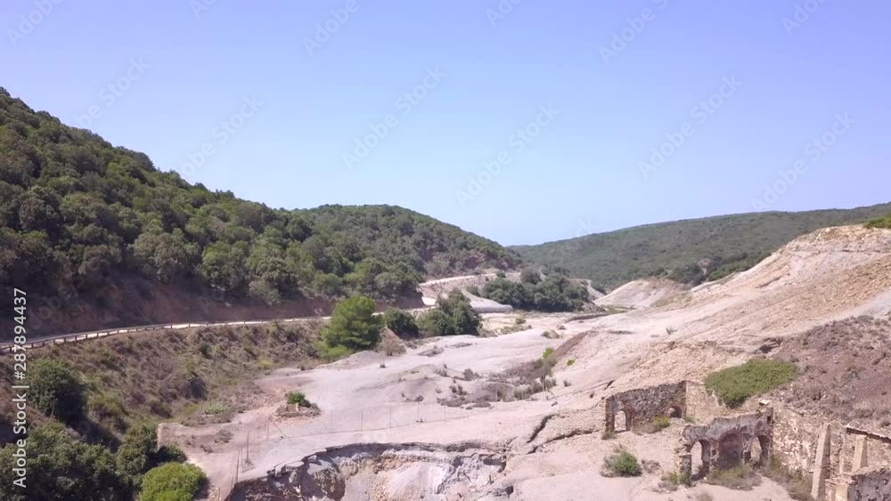 Drone shot fly over a desert road and an abandoned coal washery Brassey in Sardinia. A unique example of industrial archeology in Italy. Laveria Brassey Arbus. Sardinia Italy Drone shot fly over a desert road and an abandoned coal washery Brassey in Sardinia. A unique example of industrial archeology in Italy. Laveria Brassey Arbus. Sardinia Italy