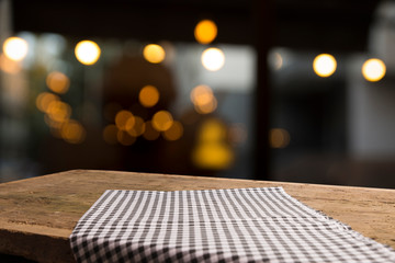 Empty wood table top on blur light gold bokeh of cafe restaurant in dark background