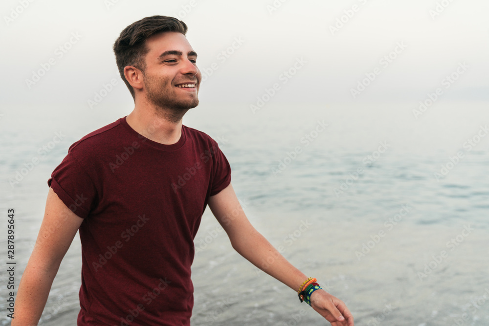 Fototapeta premium Cheerful man walking along seaside