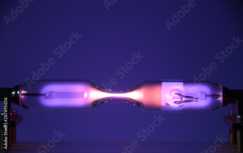 The inert gas Helium (He) seen in a discharge tube emits light due to an electric field.