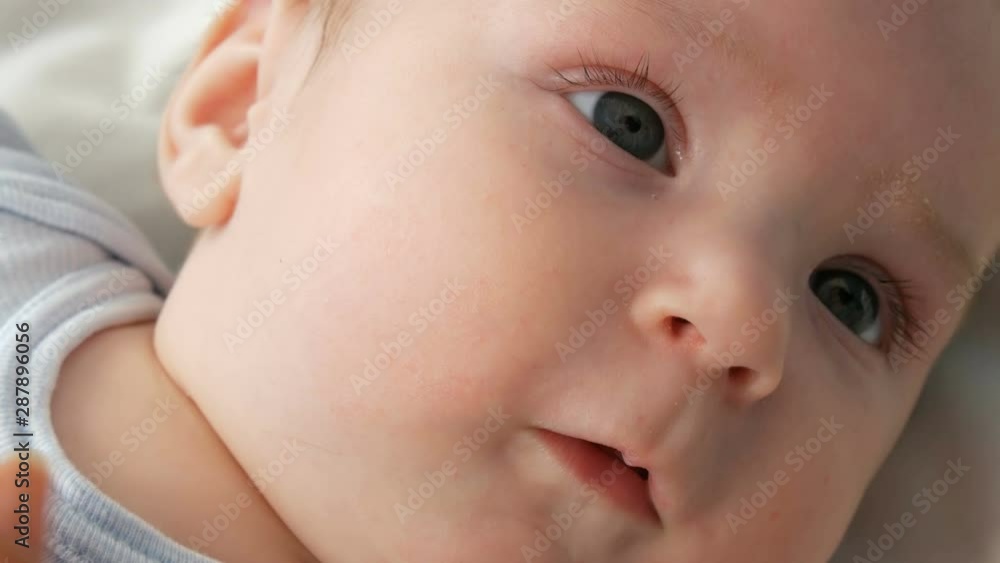 Portrait of beautiful funny little newborn baby of two months lying on a white bed Portrait of beautiful funny little newborn baby of two months lying on a white bed