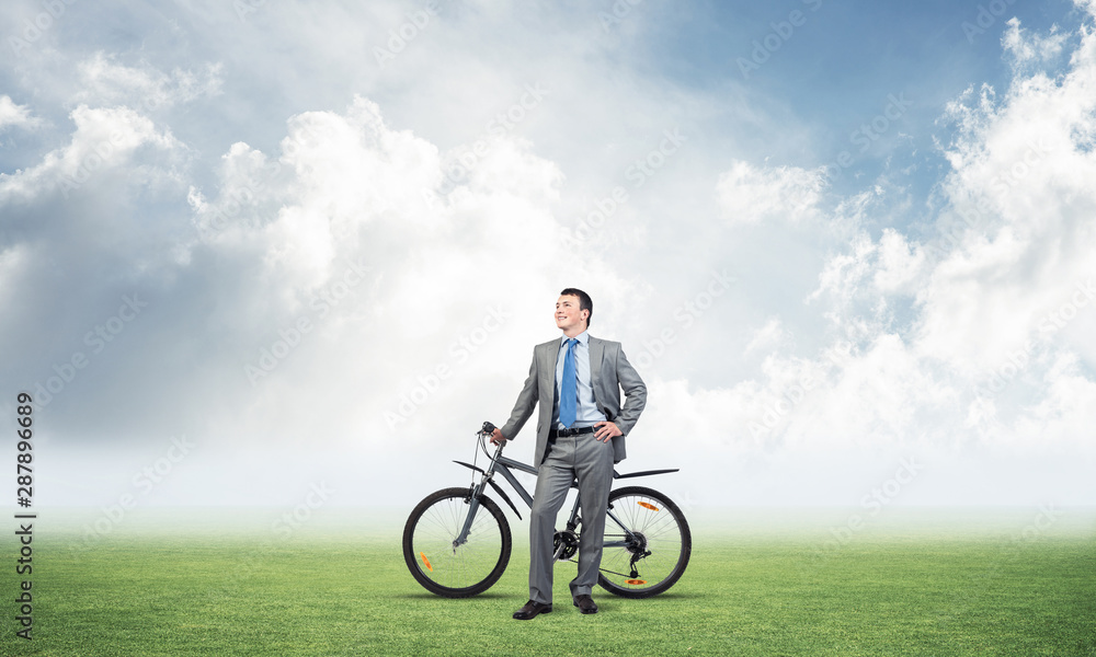 Smiling businessman with bicycle outdoors Smiling businessman with bicycle outdoors