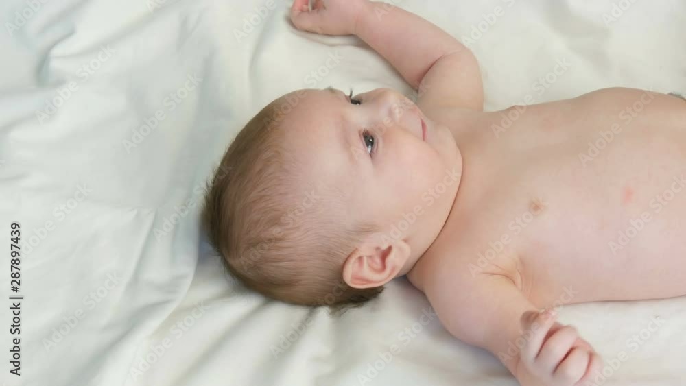 Portrait of beautiful funny little newborn baby of two months lying on a white bed Portrait of beautiful funny little newborn baby of two months lying on a white bed