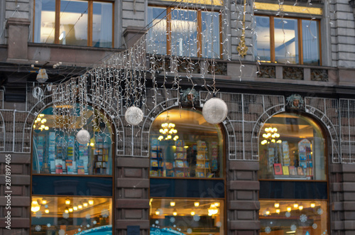 Hanging garland with balls on a blurred background lights in the windows of the facade of the house Singer (St. Petersburg, Russia)