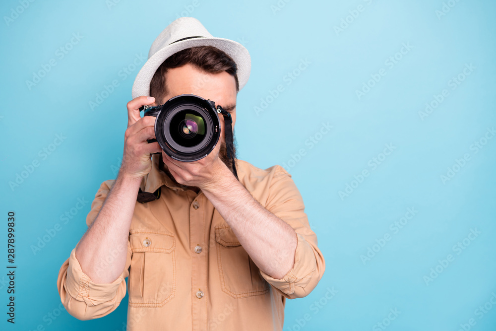 Obraz premium Portrait of concentrated person making photo looking wearing brown shirt isolated over blue background