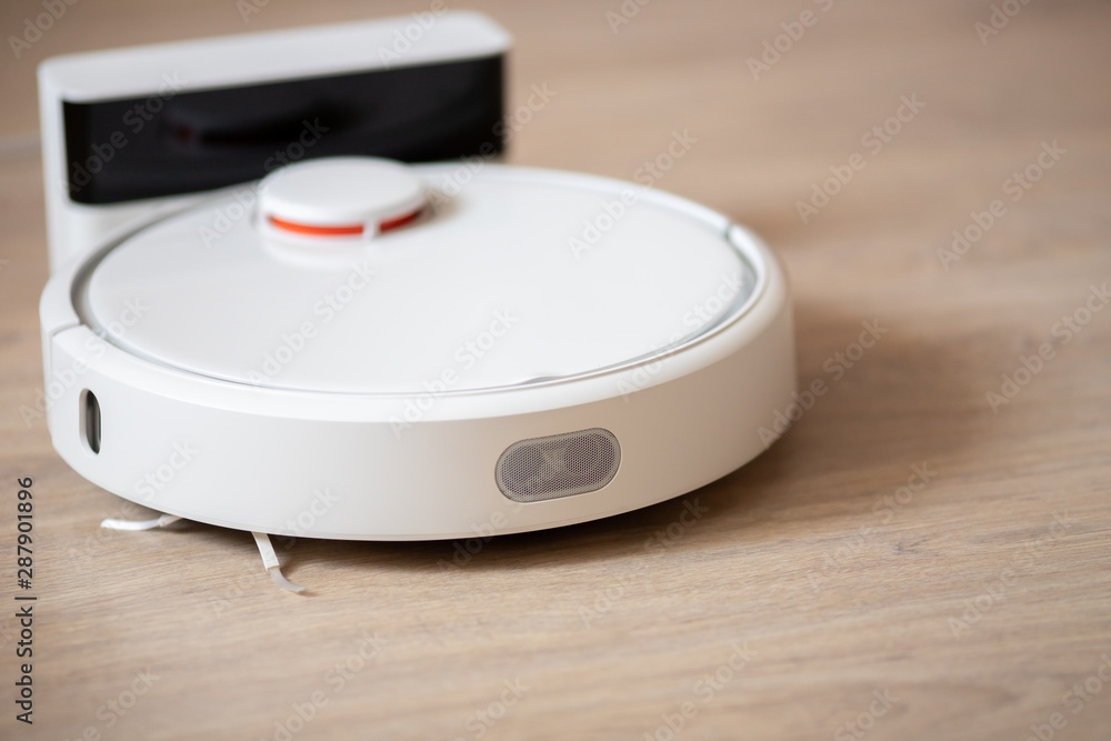 Robotic wireless smart vacuum cleaner working on laminate flooring Robotic wireless smart vacuum cleaner working on laminate flooring