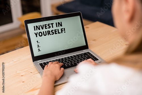 Conceptual hand writing showing Invest In Yourself. Concept meaning nvesting in a coach or a training to learn new things woman with laptop smartphone and office supplies technology photo