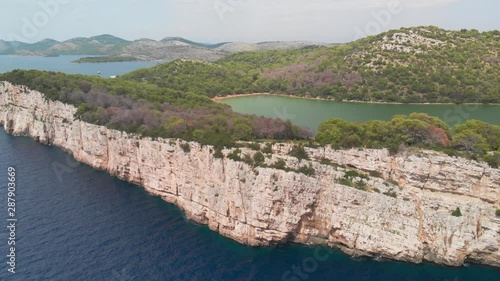 a professional looking aerial of the cliff line of island kornat in croatia, flying backwards with a slow revealing gimbal movement photo