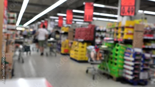 Blurred view of buyers in the vegetable department of a large grocery store. 4K