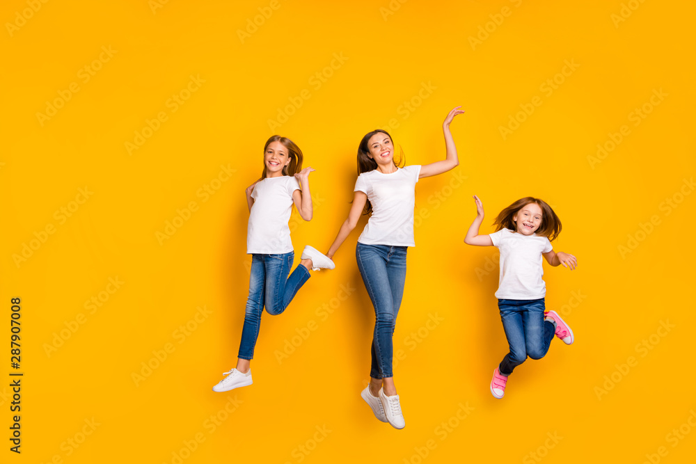 Full length photo of three ladies jumping high wear casual clothes isolated yellow background Full length photo of three ladies jumping high wear casual clothes isolated yellow background