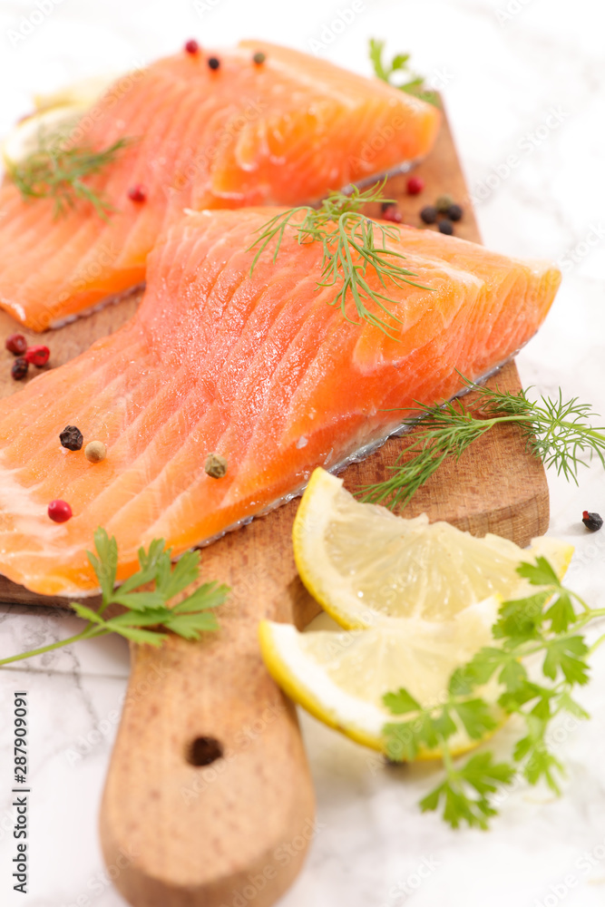 raw salmon on board with lemon and parsley