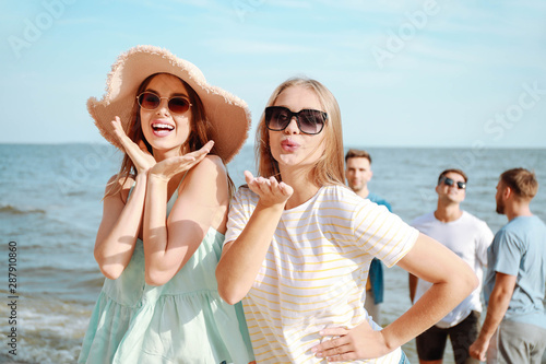 Happy friends on sea beach ...