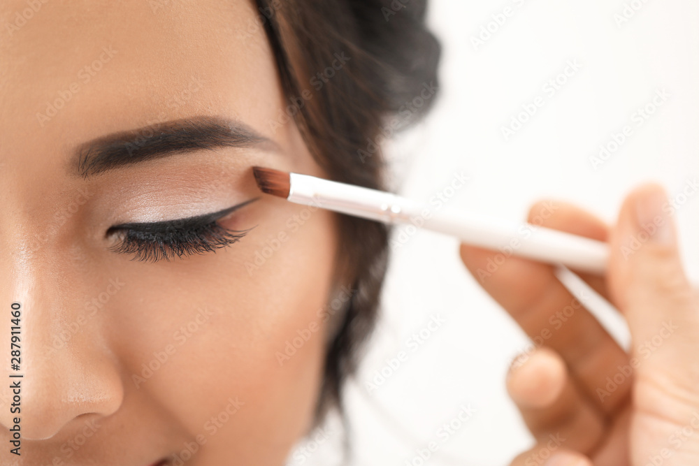 Professional makeup artist working with young Asian bride at home, closeup Professional makeup artist working with young Asian bride at home, closeup