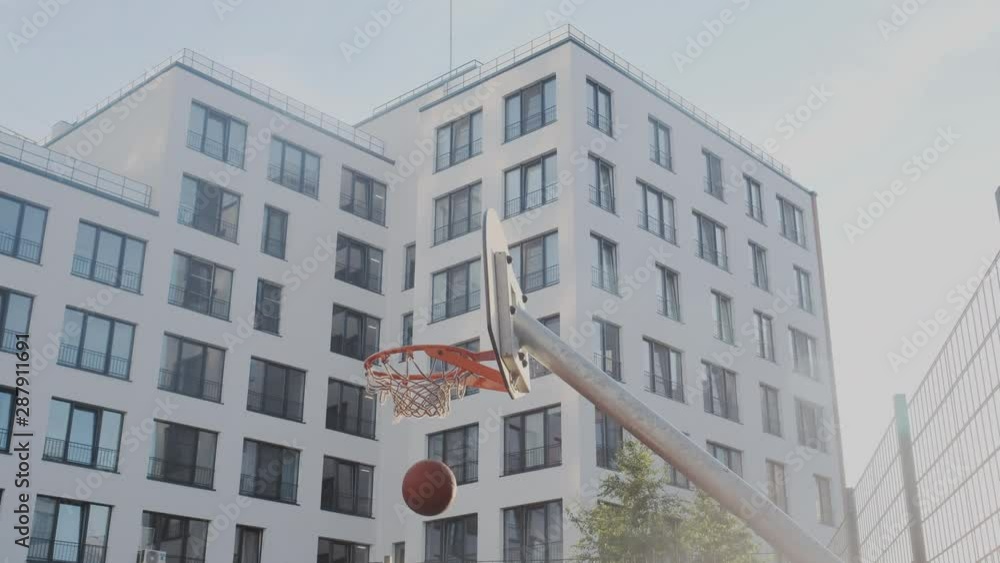 Talented Female basketball player dribbling and throwing a ball through the basket, makes a shot. Leadership, confrontation, Sun flare into the lens. Basketball court. Talented Female basketball player dribbling and throwing a ball through the basket, makes a shot. Leadership, confrontation, Sun flare into the lens. Basketball court.