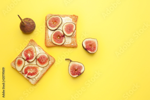 Tasty toasted bread with fig fruit on color background
