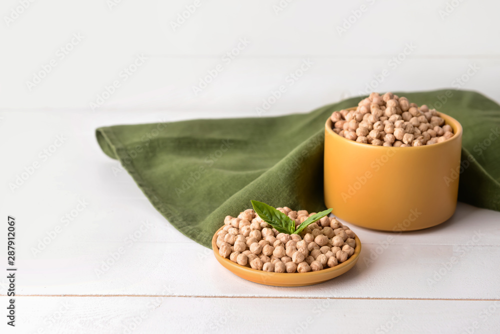 Plate and container with raw chickpea on table Plate and container with raw chickpea on table