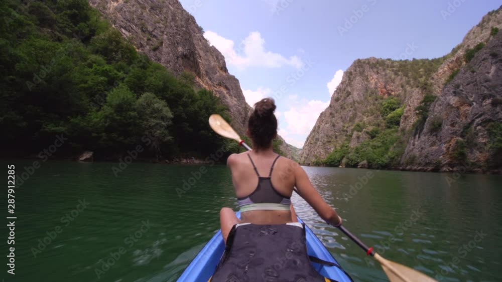 girl kayaking on calm river. Back  view