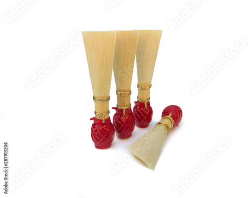 Canvas Print Double reed for bassoon with red thread on a white background
