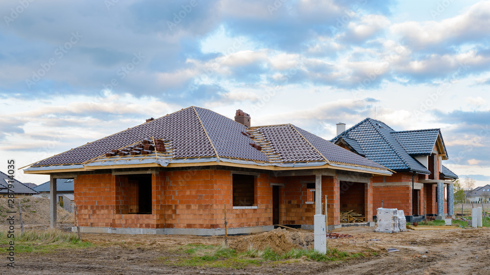 new suburban houses currently under construction against cloudy sky new suburban houses currently under construction against cloudy sky