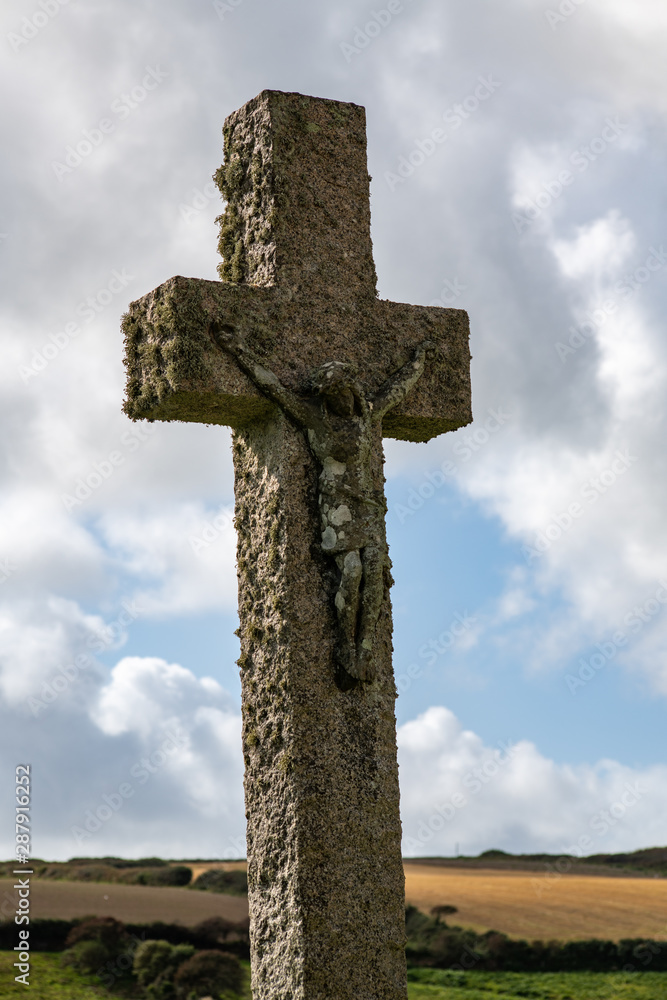 Large stone cross with a carving of Jesus on it