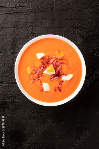 Salmorejo, Spanish chilled tomato soup, shot from the top on a black background with copyspace photo