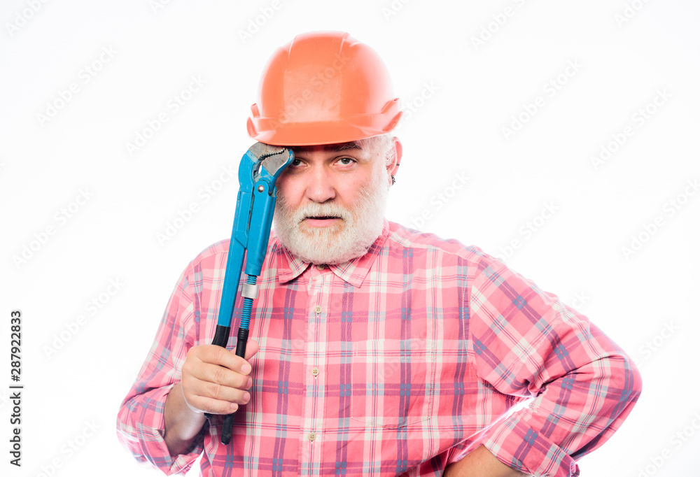Confident worker. man builder with adjustable pipe wrench. build and construction. professional repairman in helmet with gas wrench. architect repair and fix. engineer worker. mature bearded man