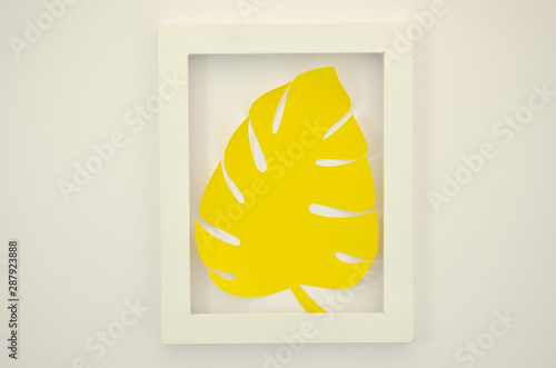 Flat lay yellow paper monstrea palm leaf in a pink plastic frame. Summer mockup photo