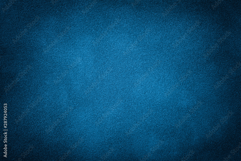 Dark blue matte background of suede fabric, closeup.