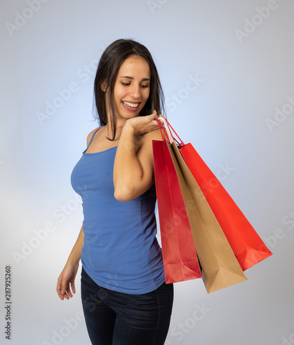 Attractive latin young teenager with shopping bags feeling overjoy and happiness