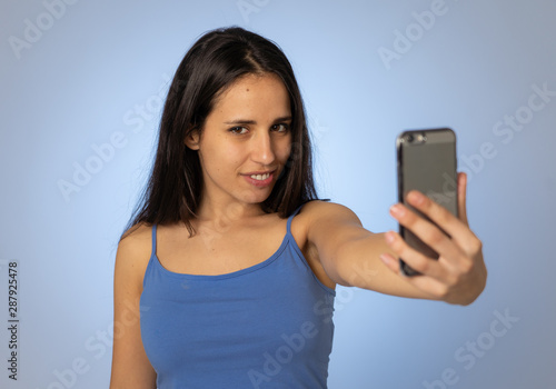 Young teenager woman taking selfie with mobile smart phone for social media